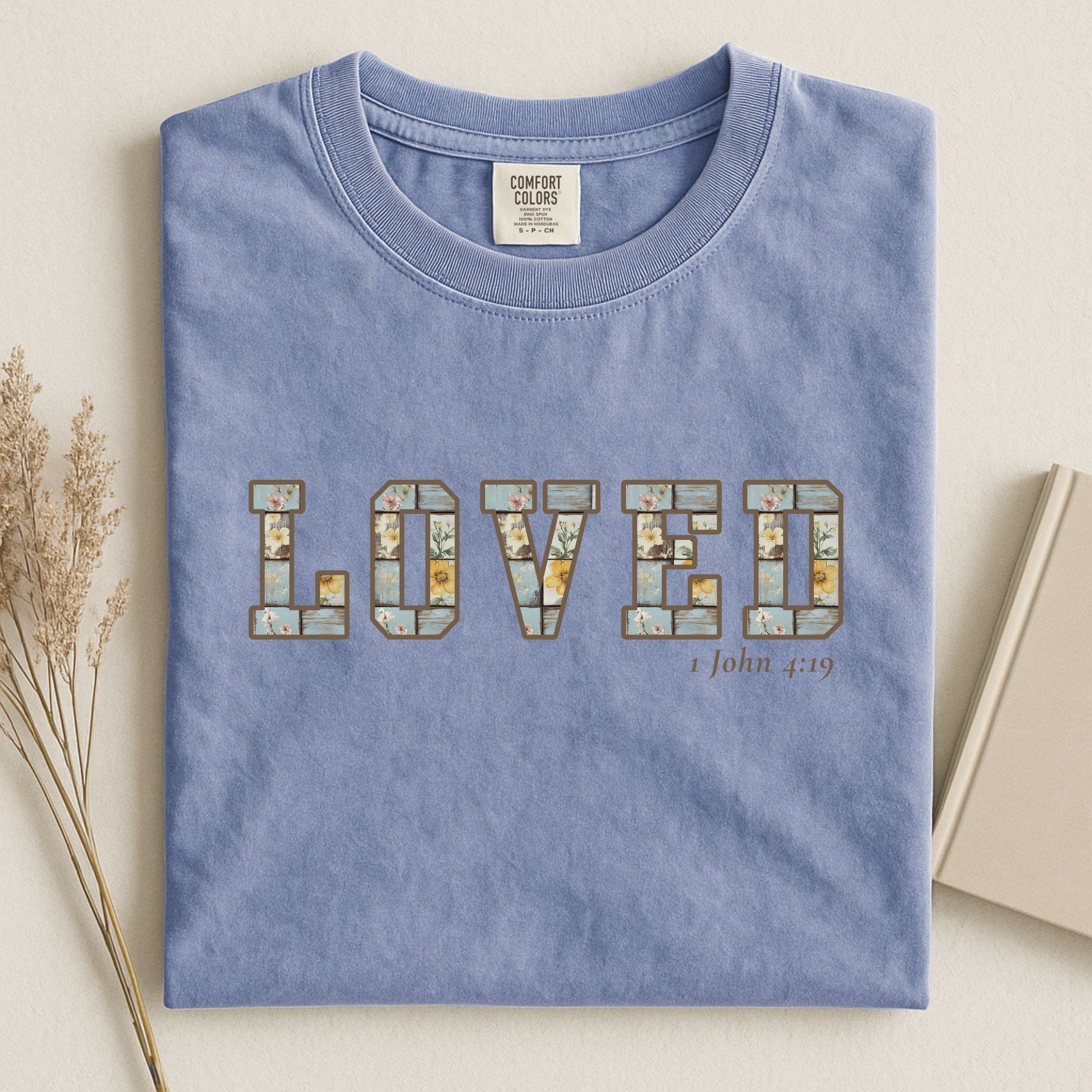Loved Christian Tee – 1 John 4:19 Faith Graphic Shirt